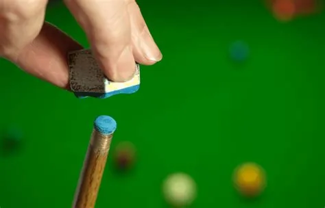 Why do snooker players wipe their cues